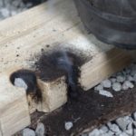 Feuerbohren ist gelungen - es glüht - man sieht ein Bowdrill Brettchen mit Glut